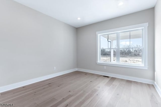 unfurnished room with light wood-type flooring, baseboards, and recessed lighting