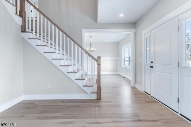 foyer featuring stairway, wood finished floors, and baseboards