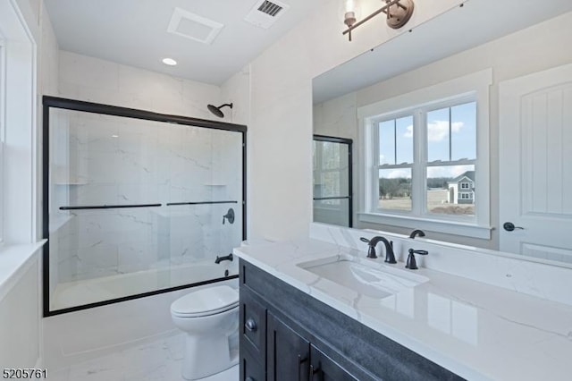 bathroom featuring marble finish floor, shower / bath combination with glass door, visible vents, toilet, and vanity