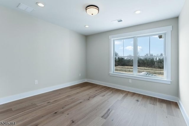 unfurnished room with recessed lighting, visible vents, baseboards, and wood finished floors