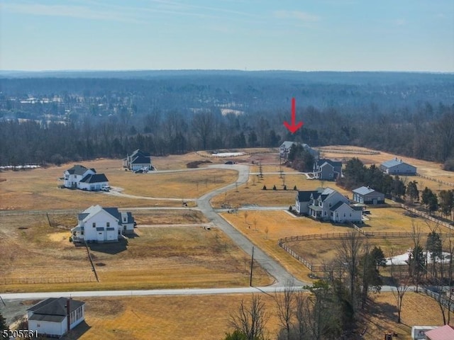 birds eye view of property featuring a rural view and a wooded view