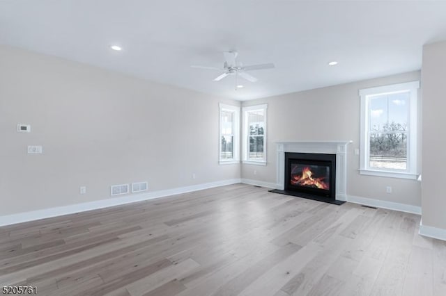 unfurnished living room with baseboards, a ceiling fan, a fireplace with flush hearth, light wood-type flooring, and recessed lighting