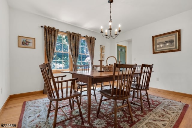 dining space with an inviting chandelier and light hardwood / wood-style floors