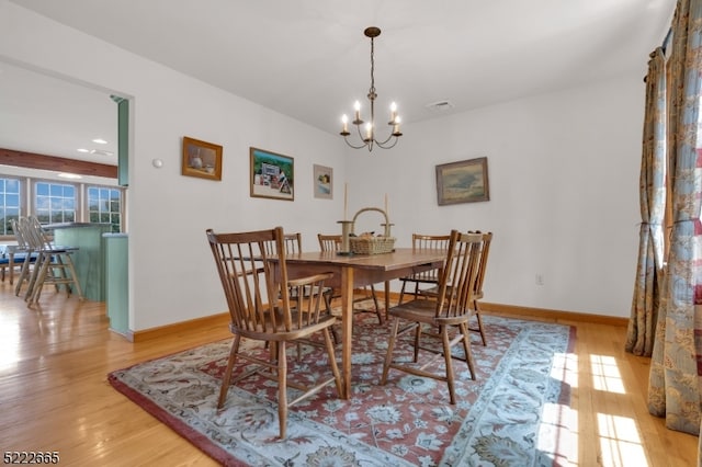 dining area featuring an inviting chandelier and light wood-type flooring