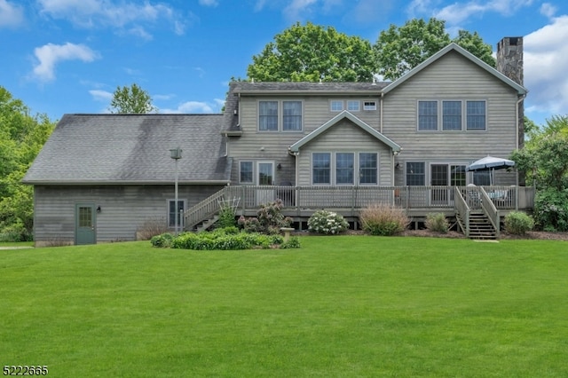 rear view of property with a wooden deck and a yard