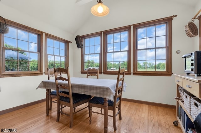 dining area featuring lofted ceiling and light wood-type flooring