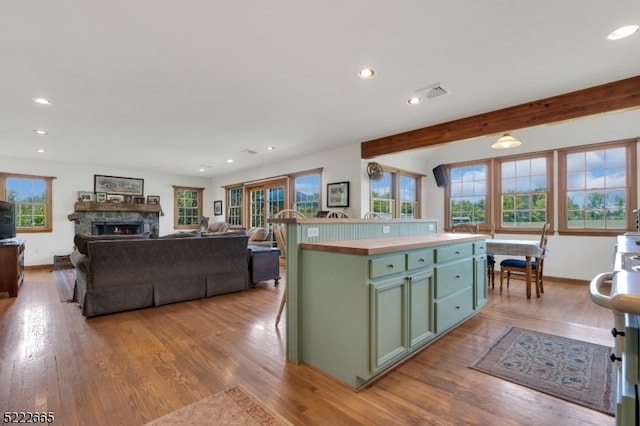 kitchen featuring green cabinetry, light wood-type flooring, and a kitchen island