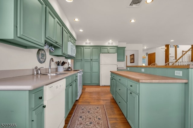 kitchen featuring sink, white appliances, and hardwood / wood-style floors