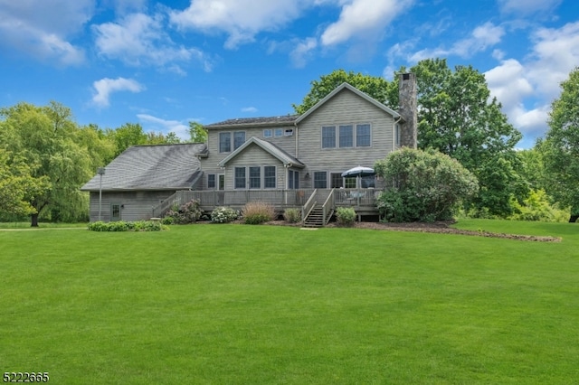 rear view of property with a lawn and a wooden deck