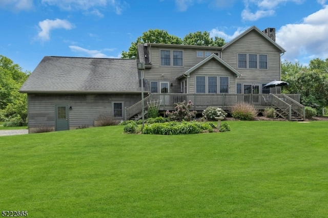 back of property with a wooden deck and a lawn