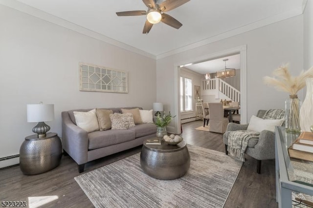 living room with a baseboard heating unit, stairway, wood finished floors, and ornamental molding