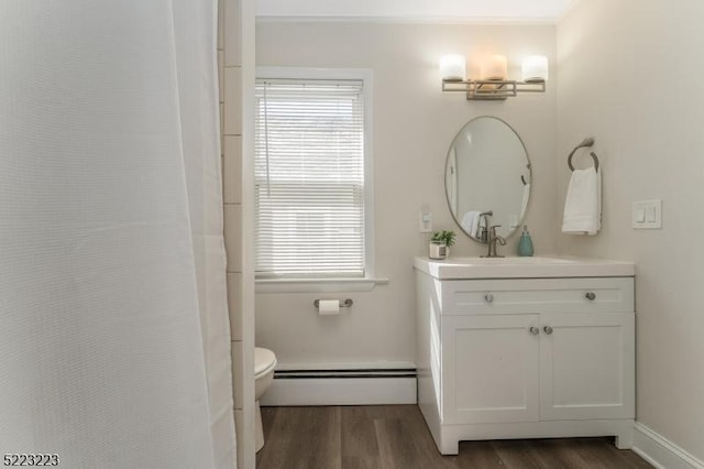 bathroom featuring toilet, plenty of natural light, wood finished floors, and a baseboard radiator