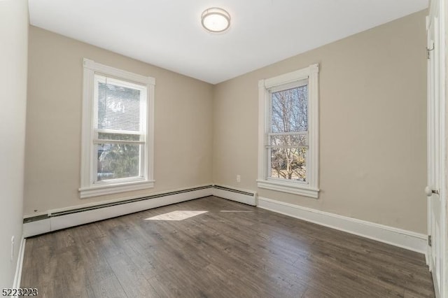 unfurnished room with wood finished floors, baseboards, and a baseboard radiator