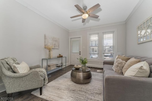 living room with crown molding, a ceiling fan, dark wood-style flooring, and baseboards