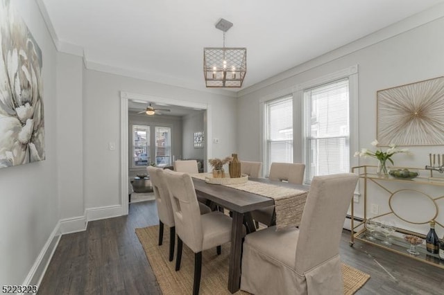 dining room with dark wood finished floors, a notable chandelier, baseboards, and ornamental molding