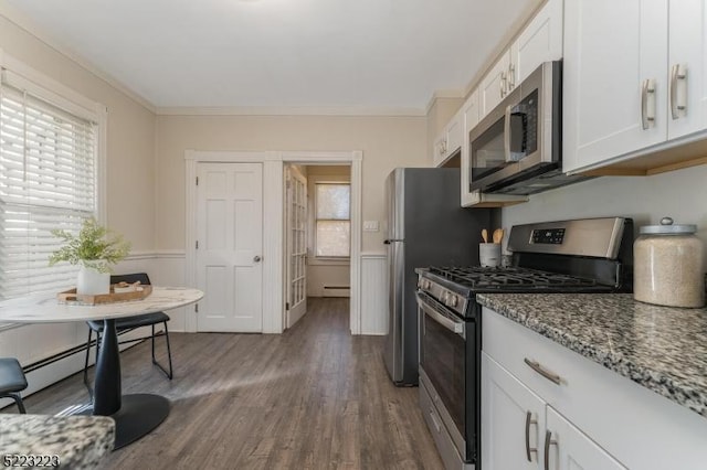 kitchen with dark wood-type flooring, ornamental molding, stone countertops, white cabinetry, and stainless steel appliances