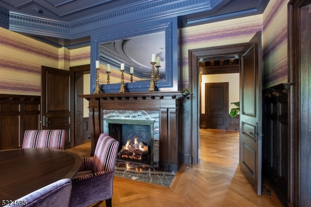 living room featuring crown molding, light parquet floors, a high end fireplace, and a tray ceiling