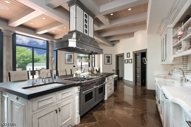 kitchen featuring range with two ovens, white cabinetry, a wealth of natural light, and sink