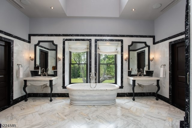 interior space with tile walls, tile flooring, a washtub, and a towering ceiling