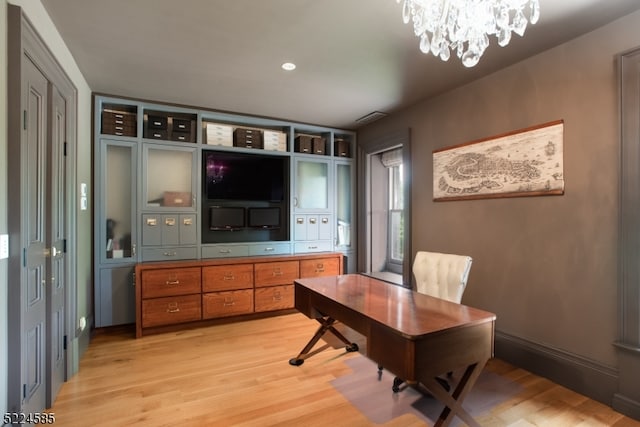 office featuring an inviting chandelier and light hardwood / wood-style floors