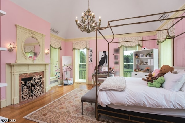 bedroom featuring an inviting chandelier, vaulted ceiling, light hardwood / wood-style floors, and multiple windows