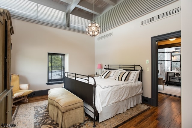 bedroom with coffered ceiling, dark wood-type flooring, beamed ceiling, and a chandelier