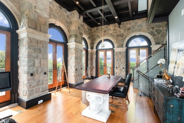 interior space with light wood-type flooring, a wealth of natural light, and french doors