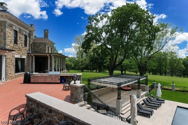 wooden deck featuring a patio, an outdoor kitchen, and a yard