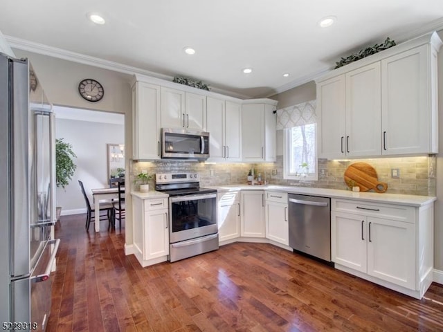 kitchen with appliances with stainless steel finishes, white cabinets, light countertops, decorative backsplash, and dark wood-style flooring