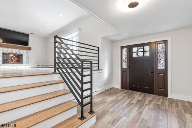 entryway with a wealth of natural light, a baseboard heating unit, and hardwood / wood-style flooring