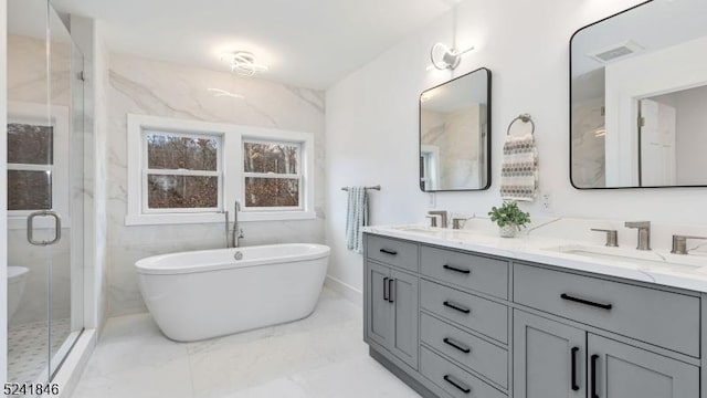 bathroom featuring vanity and independent shower and bath