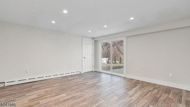 unfurnished room with light wood-type flooring and a baseboard radiator