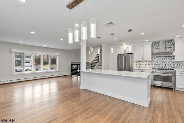 kitchen featuring white cabinetry, hanging light fixtures, wall chimney exhaust hood, and stainless steel appliances