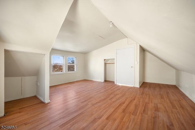 bonus room with lofted ceiling and light wood-style floors