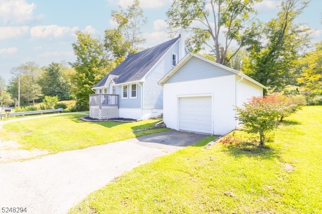 exterior space featuring a garage, a wooden deck, and a yard