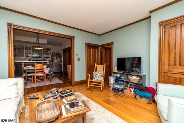 living room with ornamental molding and light hardwood / wood-style flooring