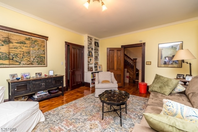 living room with crown molding, built in features, and dark hardwood / wood-style flooring