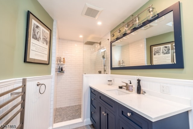 bathroom featuring a tile shower and vanity