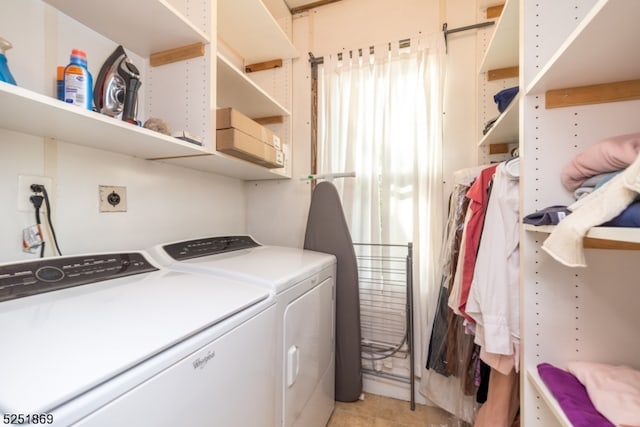 washroom with washer and clothes dryer and light tile floors