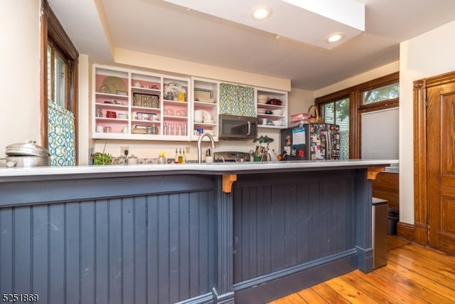 kitchen featuring fridge with ice dispenser and light hardwood / wood-style flooring