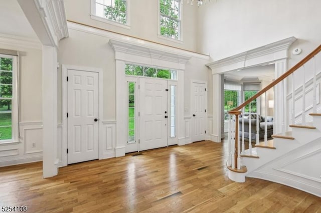30 Clairvaux Ct, Bernards Twp, NJ 07920 - entrance foyer with a towering ceiling, light wood finished floors, stairway, wainscoting, and a decorative wall