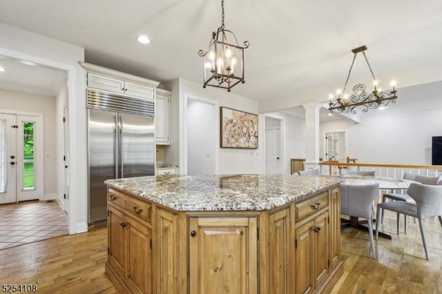 30 Clairvaux Ct, Bernards Twp, NJ 07920 - kitchen featuring built in fridge, a chandelier, decorative columns, light stone counters, and a center island