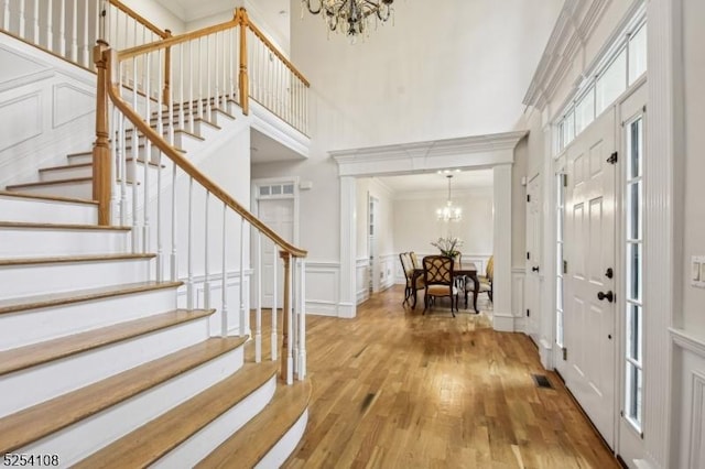 30 Clairvaux Ct, Bernards Twp, NJ 07920 - foyer featuring a chandelier, a high ceiling, stairs, a decorative wall, and wood finished floors