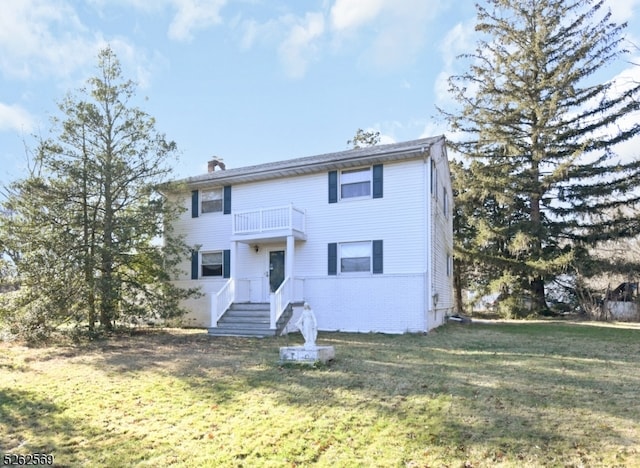 view of front of home with a balcony and a front yard