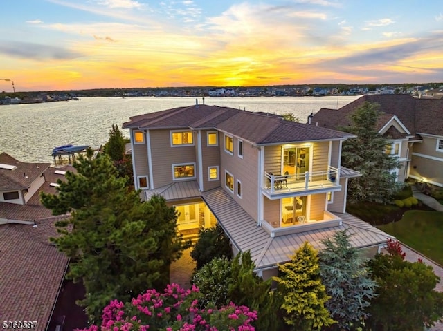 exterior space featuring a balcony and a water view