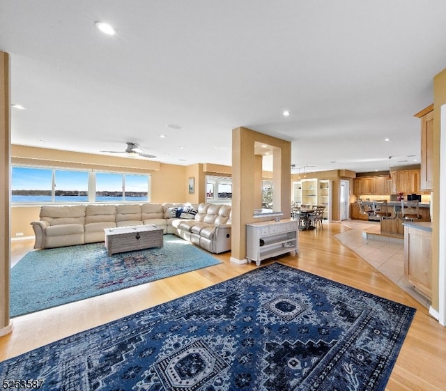 living room with light hardwood / wood-style flooring and ceiling fan