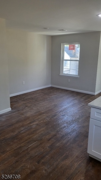 spare room with dark wood-type flooring