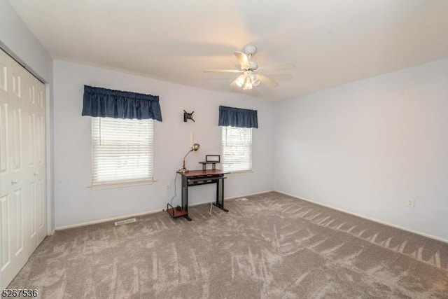 interior space with carpet floors and a ceiling fan