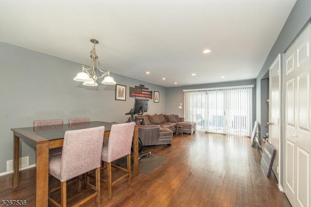 dining room with an inviting chandelier, visible vents, dark wood-type flooring, and recessed lighting