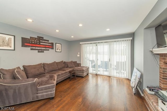 living area with a fireplace, wood finished floors, and recessed lighting